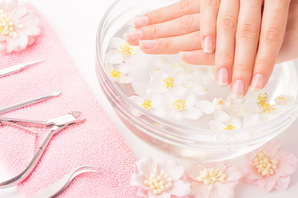 Beautiful woman's hands with manicure in bowl of water